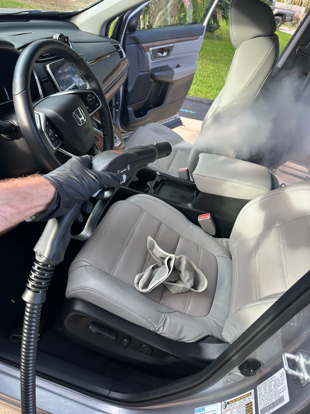 Gulf Coast Detailers steam cleaning leather front seats during mobile interior car detailing